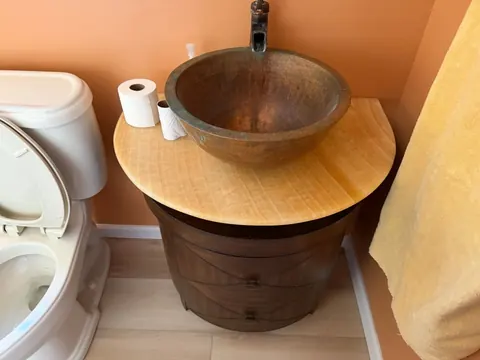 Finished bathroom with new plank flooring, vanity with copper vessel sink